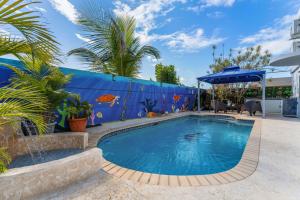 a swimming pool with a blue wall and palm trees at Gaviota del Mar with private pool in Rincon