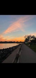 a walkway next to a river with a sunset at No7-Corner Studio in Bridgeport