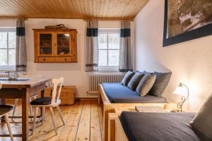 a living room with a blue couch and a table at Rinntaverne in Palfau