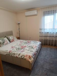 a bedroom with a bed with a floral bedspread at Martin's Apartment in Bansko