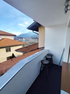 a balcony with two bar stools and a view at Martin's Apartment in Bansko