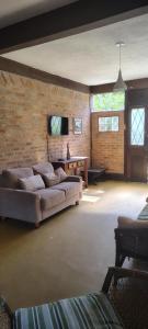 a bedroom with a large bed and a brick wall at Catavento Flats e Suítes in Maresias