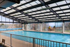a large swimming pool with a person walking in front of it at Swanage Luxury Caravan - Stunning sea views, Large decking area, Free EE WIFI, Sleeps 6, Pet Friendly on Swanage Bay View Holiday Park in Swanage