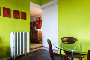 une salle à manger avec des murs verts et une table et des chaises en verre dans l'établissement Abchouse Sant'Agostino, à Milan