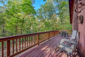 a deck with two chairs sitting on it at Fox Hollow - Hot Tub, Wifi, Pet Friendly, Screen Porch, Deck, Recreation Center, Pool Access, Golf Nearby, Hiking, Grill, Fireplace, King Bed in Hedgesville