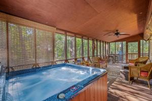 a large jacuzzi tub in a room with windows at Fox Hollow - Hot Tub, Wifi, Pet Friendly, Screen Porch, Deck, Recreation Center, Pool Access, Golf Nearby, Hiking, Grill, Fireplace, King Bed in Hedgesville