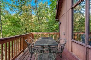 a table and chairs on the deck of a cabin at Fox Hollow - Hot Tub, Wifi, Pet Friendly, Screen Porch, Deck, Recreation Center, Pool Access, Golf Nearby, Hiking, Grill, Fireplace, King Bed in Hedgesville +28 photos