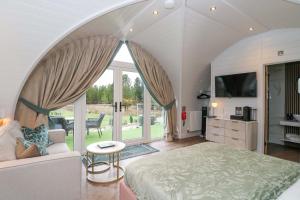 a large bedroom with a large bed and a tv at Crofters Suite in Acharacle