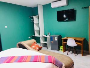a bedroom with a bed and a desk and a tv at Makgadikgadi Riverview Inn in Nata