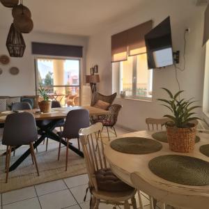 a dining room and living room with a table and chairs at Anemõessa in Korinthos