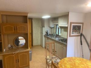 a kitchen with wooden cabinets and a table in it at Rancho Catalan 2 in Castillo de Aro
