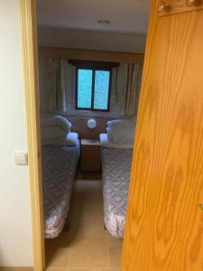 a small room with two beds and a window at Rancho Catalan 2 in Castillo de Aro