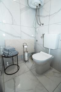 a white bathroom with a toilet and a sink at Studioapartment Black & White in Velika Gorica +49 photos