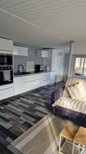 a living room with a couch and a kitchen at Chalet in Saint-Anthème
