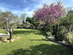 a yard with trees and grass with purple flowers at Alice's Studio and Oasis in Poitiers
