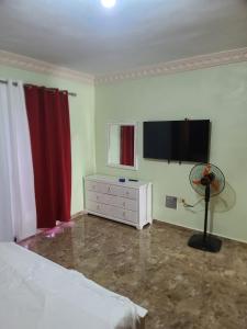 a bedroom with a bed and a flat screen tv at Apartahotel Henry Winche in Sabana Grande de Boyá