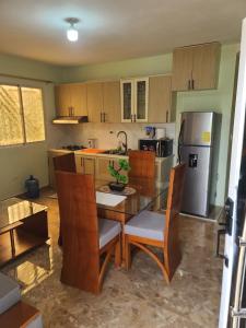 a kitchen with a table and chairs and a refrigerator at Apartahotel Henry Winche in Sabana Grande de Boyá