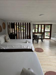 a bedroom with two beds and a dining room at Cabañas Valle del Cocora La Truchera in Salento +112 photos
