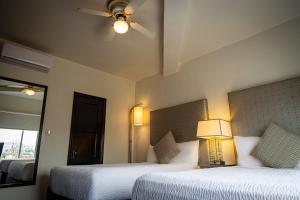 una camera d'albergo con due letti e un ventilatore a soffitto di Hotel Nelson a Tijuana