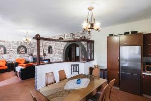 a kitchen and living room with a table and a refrigerator at Garden Villa Dhesara in Ksamil