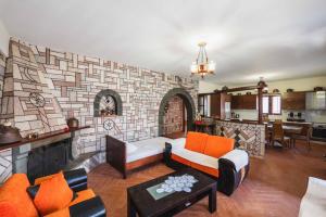 a living room with a couch and a brick wall at Garden Villa Dhesara in Ksamil