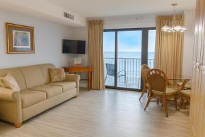 a living room with a couch and a table at Boardwalk One- Studio w Balcony and Partial Ocean View in Ocean City