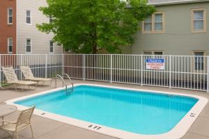 a swimming pool in front of a building with a fence at Boardwalk One- Studio w Balcony and Partial Ocean View in Ocean City