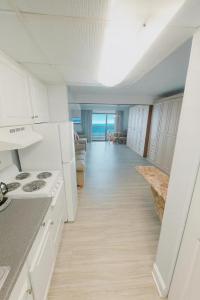 a kitchen with white appliances and a hallway with the ocean at Boardwalk One- Studio w Balcony and Partial Ocean View in Ocean City +6 photos