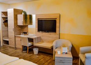 a room with a desk and a table and chairs at Ailwaldhof Parkhotel & Spa in Baiersbronn