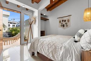 a white bedroom with a bed and a balcony at Costa Dorada - Beachfront Penthouse in Bucerias Golden Zone in Bucerías