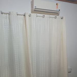 a bathroom with a shower curtain and a heater at Aluguel Nova Tramandaí in Tramandaí