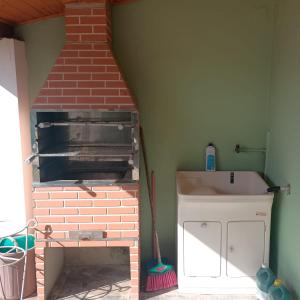 a kitchen with a brick oven in a room at Aluguel Nova Tramandaí in Tramandaí