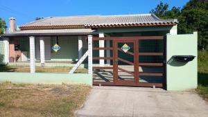 a house with a gate and a fence at Aluguel Nova Tramandaí in Tramandaí