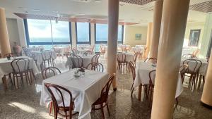 a restaurant with tables and chairs with white table cloth at Zeeva Hotel and Resort in Torre Dei Corsari