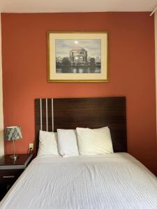 ein Schlafzimmer mit einem Bett und einer orangefarbenen Wand in der Unterkunft Europa Hotel in San Francisco