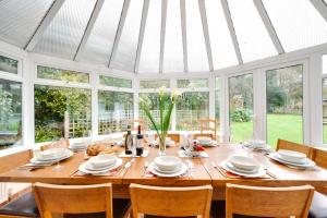 a dining room with a large wooden table with chairs at 5 Bed in Croyde oc-brambc in Croyde