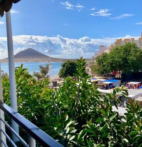 a balcony with a view of a beach and a mountain at Ocean Breeze & View Médano in El Médano +5 photos