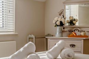 a room with white towels and a table with a mirror at 4 Bed in Westleton oc-s27303 in Westleton +21 photos