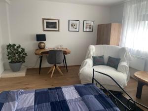 a living room with a white chair and a table at Wellness Varaždin in Varaždin