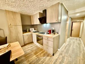 a small kitchen with wooden cabinets and a table at Le Jacuzzi Room in Perpignan
