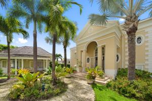 a house with palm trees in front of it at Sugar Hill Resort, Bananaquit in Saint Joseph