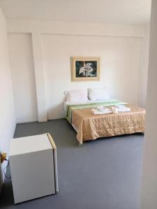 a white room with a bed and a table at Hotel BH Center in Belo Horizonte