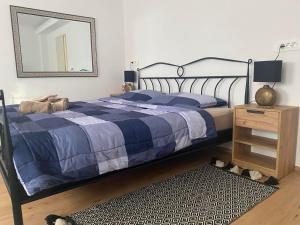 a bedroom with a bed with a blue blanket and a mirror at Wellness Varaždin in Varaždin