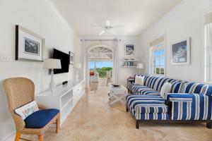 a living room with a blue and white couch and chairs at Sugar Hill Resort, Bananaquit in Saint Joseph
