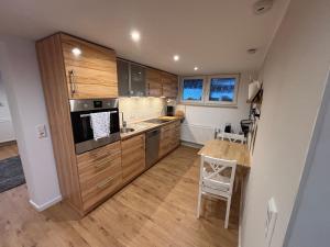 a kitchen with wooden cabinets and a table in it at Apartment am Grimmsteig in Nieste