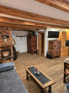 a living room with a fireplace and a table at Jaśkowa Chata Bieszczady apartament z basenem nr 1i2 in Baligród