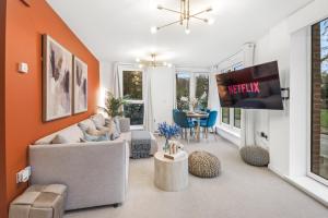 a living room with a couch and a tv at Central Hemel 2-Bed Flat with Secure Parking in Hemel Hempstead