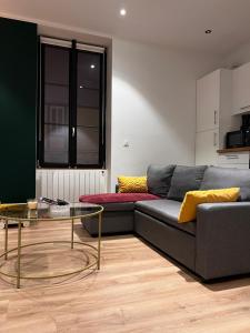 a living room with a couch and a glass table at L'arquebuse - Gare Dijon in Dijon
