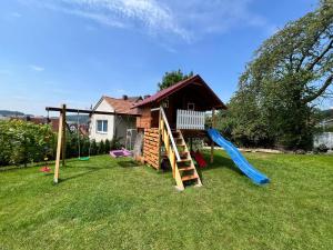 a yard with a playground with a slide and a house at Apartment am Grimmsteig in Nieste