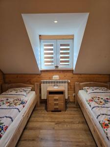 a room with two beds and a window at Jaśkowa Chata Bieszczady apartament z basenem nr 1i2 in Baligród